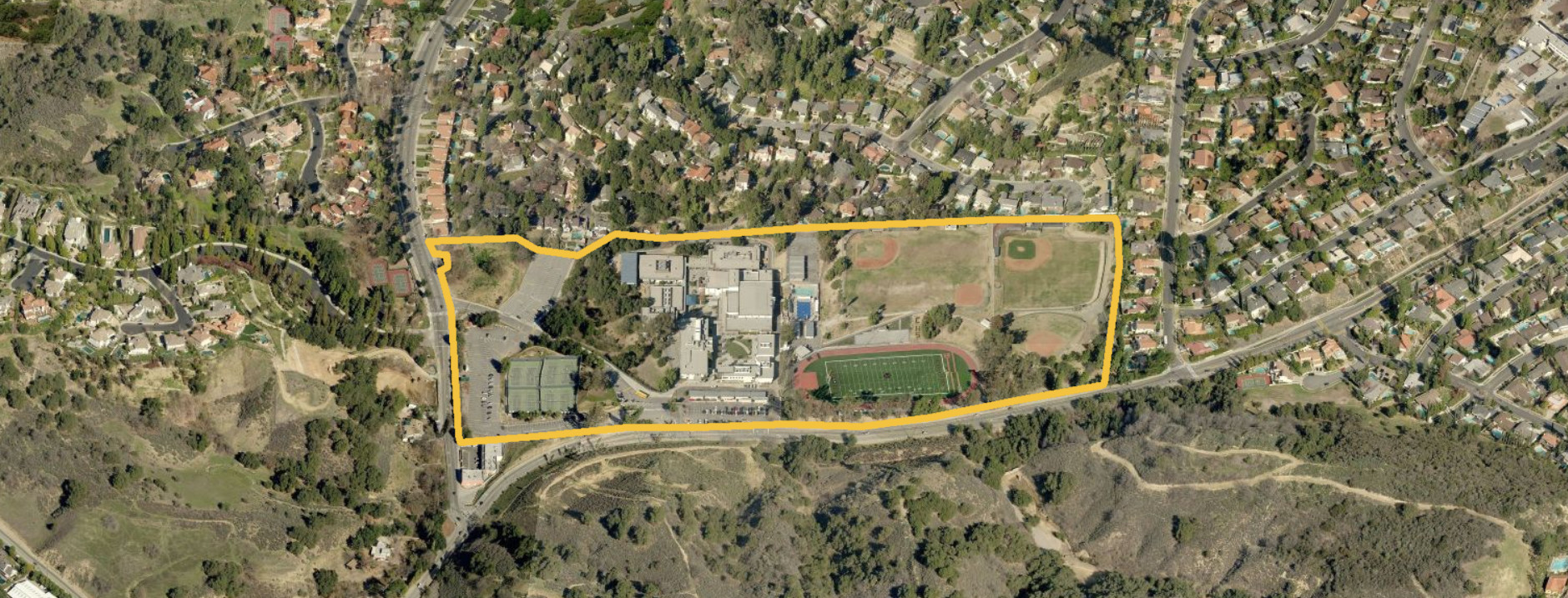 Aerial image of a school taken from the California School Campus Database, the campus includes school buildings, parking lots, ballfields, tennis courts, a football field, track and open areas.